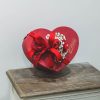 caja con forma de corazón rellena con rosas rojas