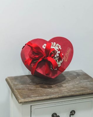 caja con forma de corazón rellena con rosas rojas